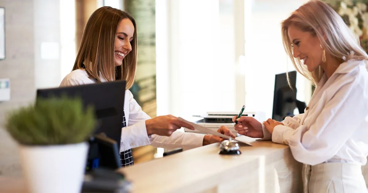 A receptionist giving full attention to the visitor in front of them